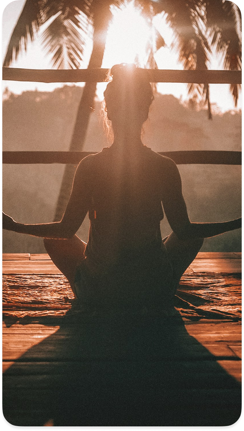A person taking a calm moment outdoors at sunset