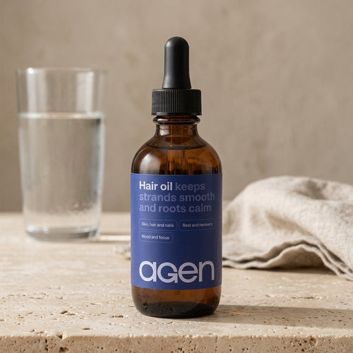Agen Hair Oil bottle on a travertine counter in soft morning light