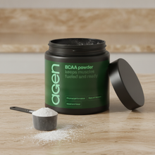 Agen BCAA Powder — open tub with a scoop of powder on a stone counter