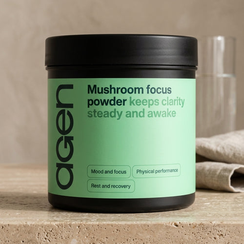 Agen Mushroom Focus Powder tub on a travertine counter in soft morning light