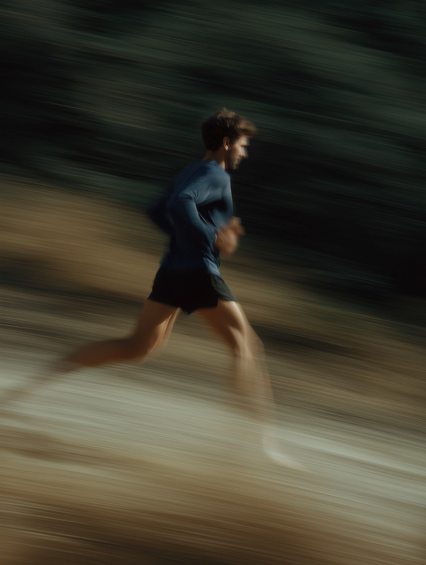 Runner in full stride on a trail, motion-blurred