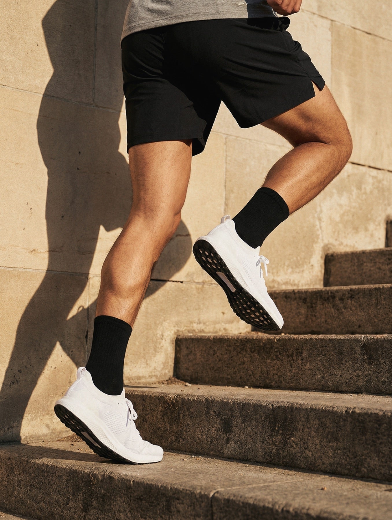 Runner pushing up stone steps in harsh light
